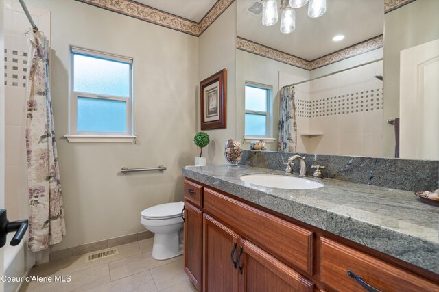 bathroom featuring tile patterned flooring, curtained shower, vanity, and toilet