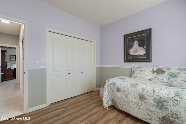 bedroom with light hardwood / wood-style flooring and a closet