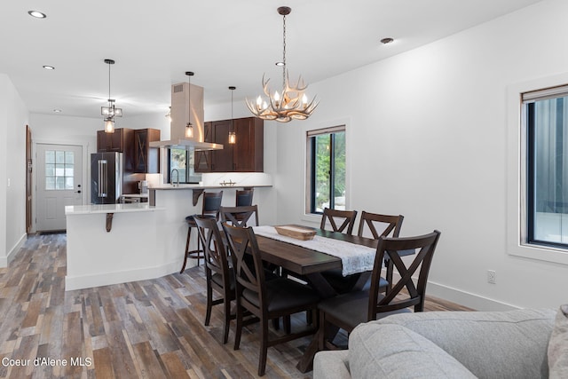dining space with plenty of natural light, an inviting chandelier, and light wood-style floors