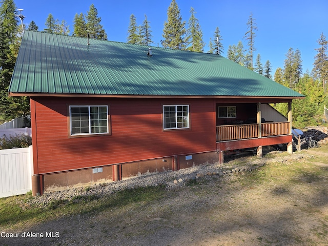 view of side of home featuring metal roof and crawl space