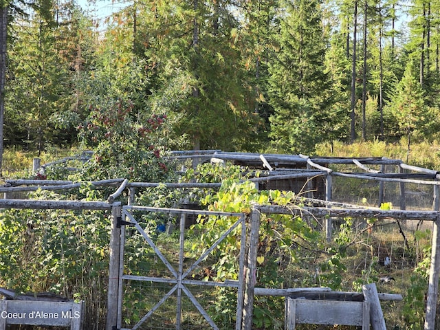view of yard with a gate and a wooded view