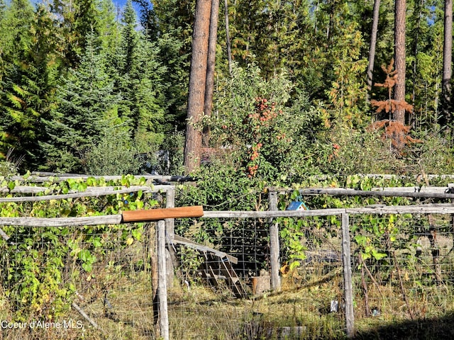 view of yard featuring fence and a wooded view
