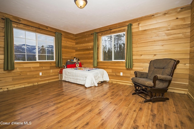 bedroom featuring wood walls and wood finished floors