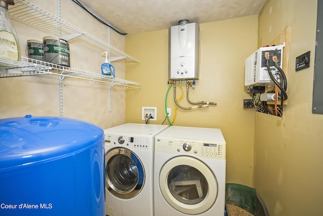 washroom with water heater, laundry area, and washer and clothes dryer