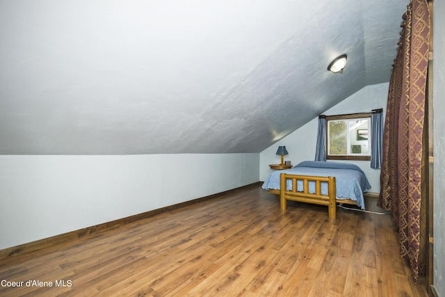 bedroom featuring lofted ceiling and hardwood / wood-style flooring