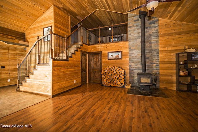 unfurnished living room featuring wooden ceiling, hardwood / wood-style flooring, wood walls, and high vaulted ceiling