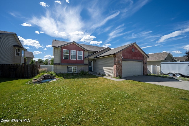 split level home with fence, an attached garage, concrete driveway, and a front lawn