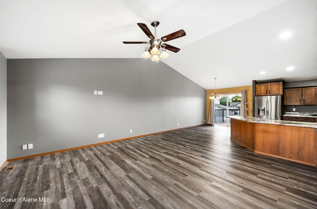 kitchen with dark wood-style flooring, lofted ceiling, open floor plan, stainless steel refrigerator with ice dispenser, and light countertops