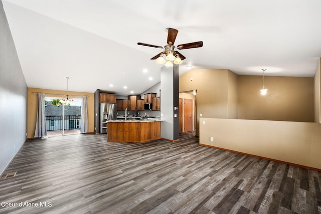 unfurnished living room featuring ceiling fan with notable chandelier, lofted ceiling, and dark hardwood / wood-style flooring