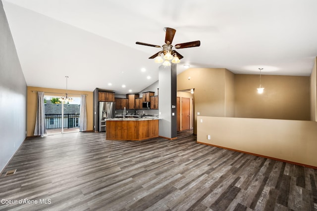 kitchen with appliances with stainless steel finishes, light countertops, open floor plan, vaulted ceiling, and dark wood-style floors