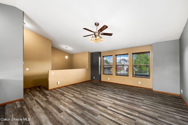 spare room with visible vents, lofted ceiling, wood finished floors, baseboards, and a ceiling fan