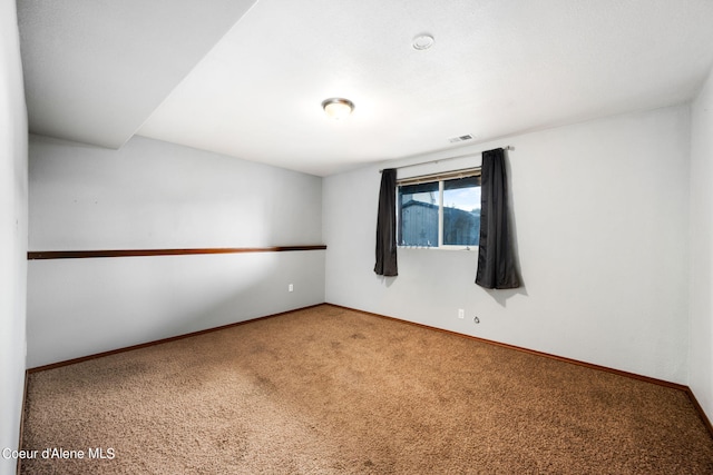 empty room with baseboards, carpet flooring, and visible vents
