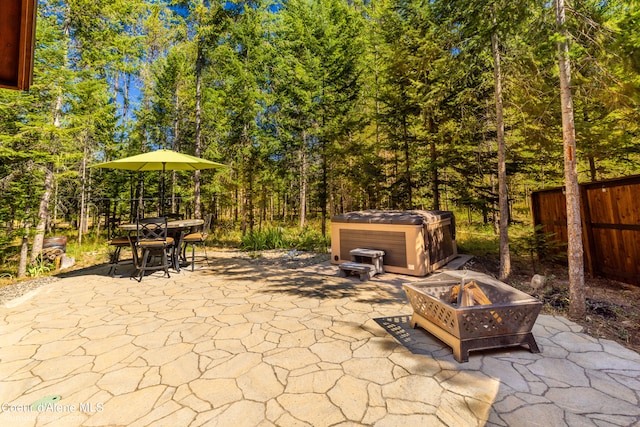 view of patio with an outdoor fire pit and a hot tub