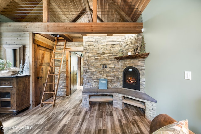 unfurnished living room featuring hardwood / wood-style flooring, beamed ceiling, a fireplace, and wood ceiling