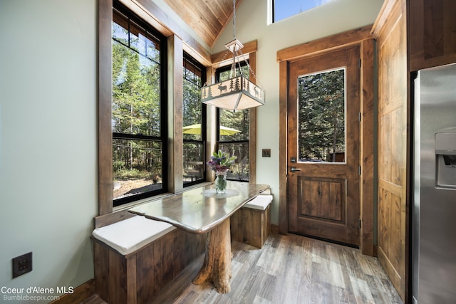 doorway featuring vaulted ceiling, wooden ceiling, and light hardwood / wood-style floors