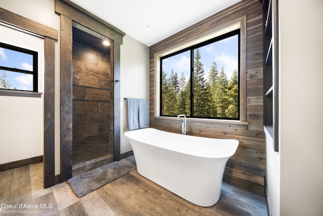 bathroom featuring wood walls, shower with separate bathtub, and hardwood / wood-style flooring