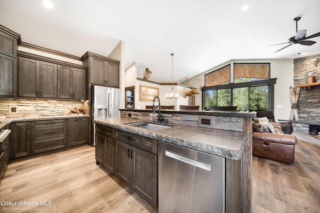 kitchen featuring dishwasher, hanging light fixtures, sink, and light wood-type flooring