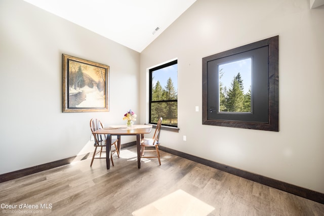 dining room with lofted ceiling and light wood-type flooring