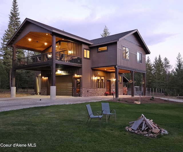 back house at dusk with a garage and a yard