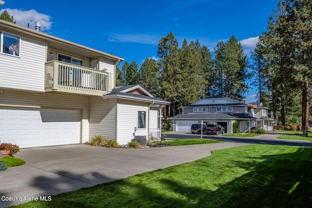 view of side of home featuring a lawn, a balcony, and a garage