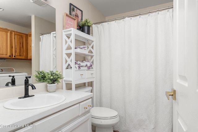 bathroom featuring vanity, washer / clothes dryer, and toilet