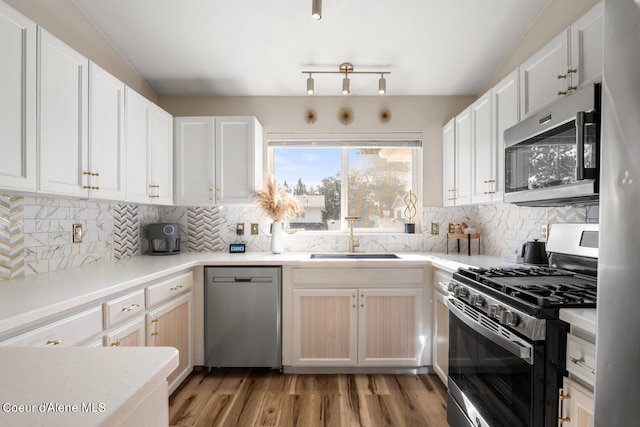 kitchen with sink, white cabinetry, and stainless steel appliances