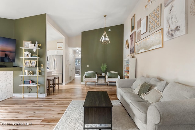 living room featuring a notable chandelier, high vaulted ceiling, and wood-type flooring