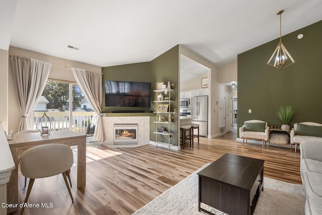 living room featuring light hardwood / wood-style flooring and vaulted ceiling