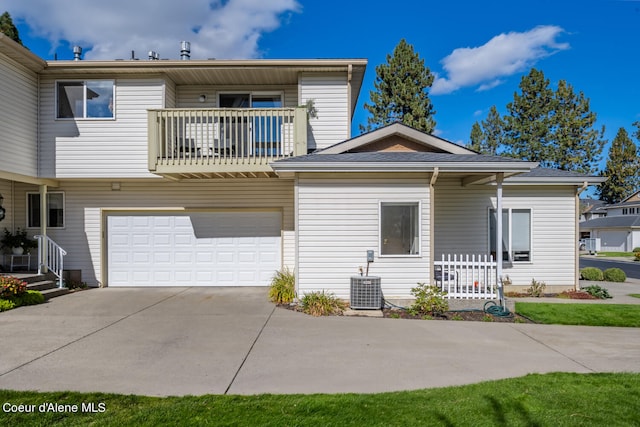 rear view of house featuring central AC, a balcony, and a garage