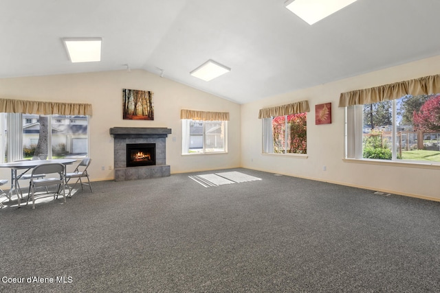 unfurnished living room featuring lofted ceiling, a tiled fireplace, and carpet flooring