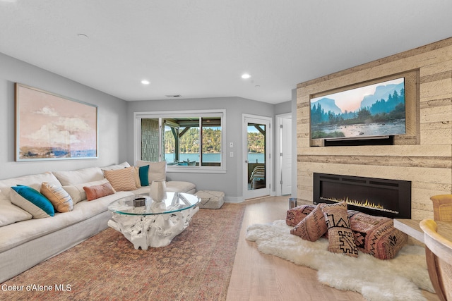 living room with a large fireplace and hardwood / wood-style floors