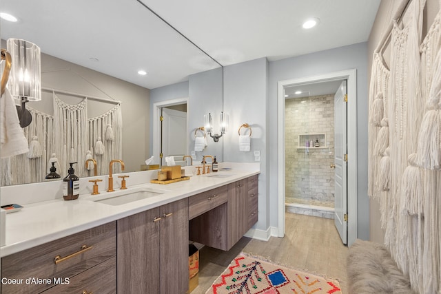 bathroom with vanity, a shower with shower door, and hardwood / wood-style floors