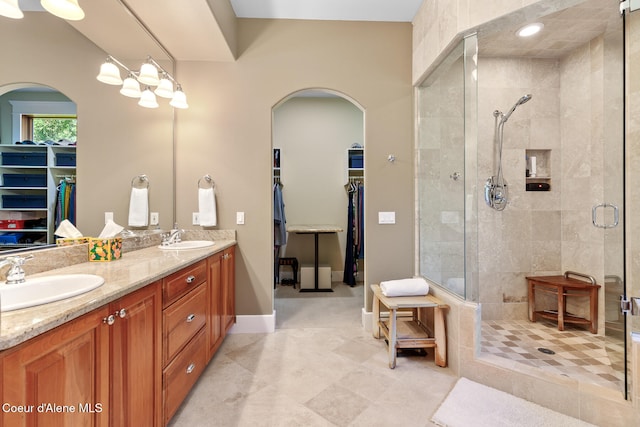 bathroom with tile patterned flooring, a shower with shower door, and vanity