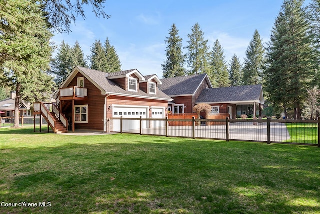 back of house featuring a yard, an attached garage, fence, and stairs