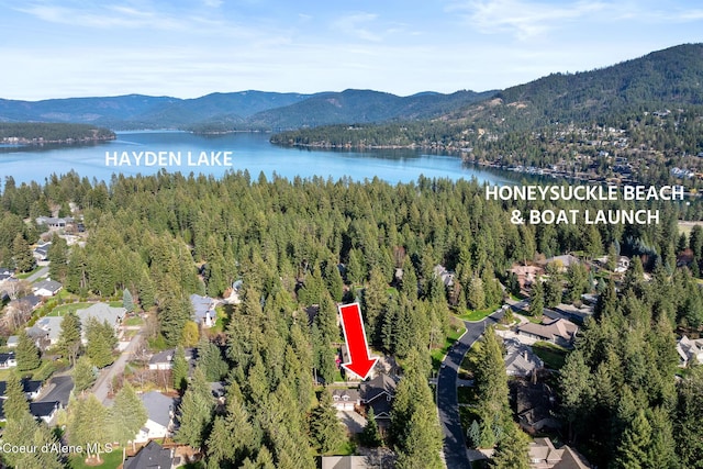birds eye view of property with a view of trees and a water and mountain view