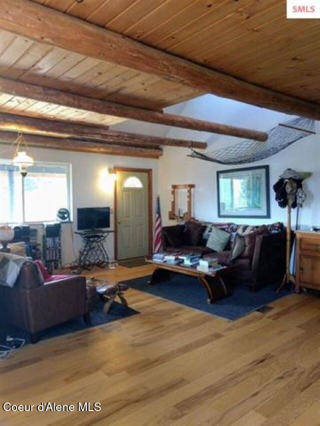 living room with wooden ceiling, beamed ceiling, and hardwood / wood-style flooring