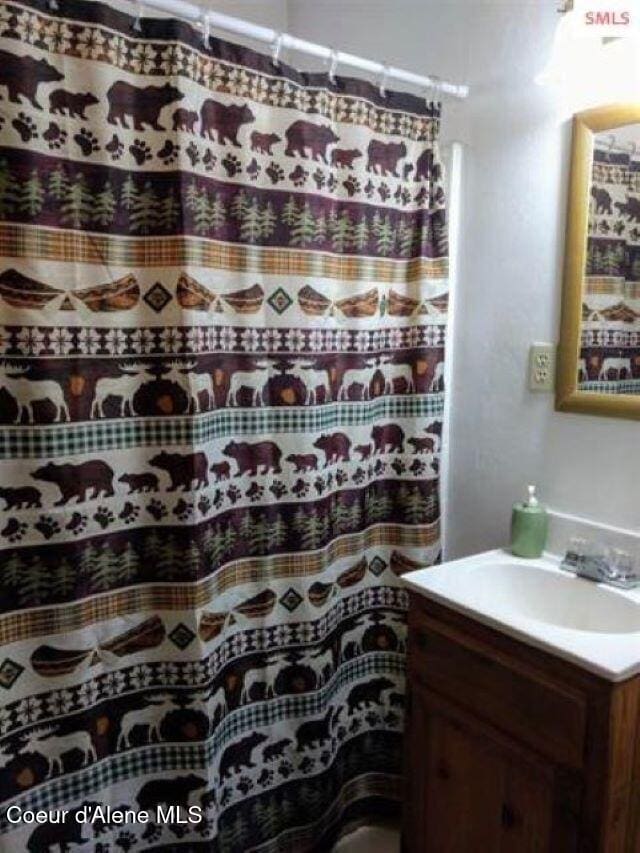 bathroom featuring curtained shower and vanity