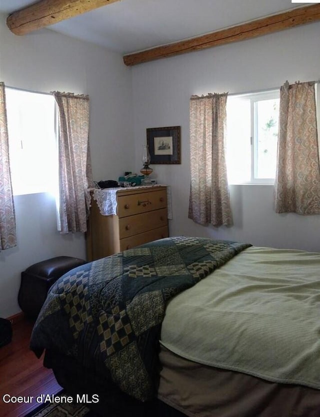 bedroom with beam ceiling and wood-type flooring