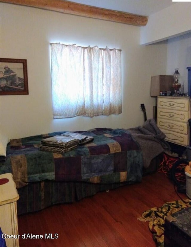 bedroom featuring beam ceiling and dark hardwood / wood-style floors