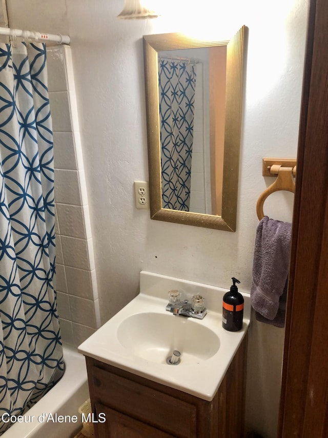 1452 Grizzly Gap Rd, Naples, ID 83847 - bathroom featuring vanity, shower / bath combo with shower curtain, and a textured wall