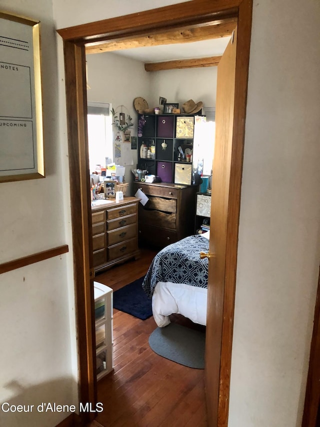 bedroom with beamed ceiling and wood-type flooring