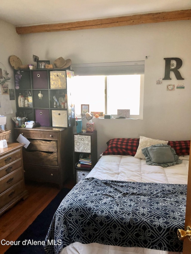 bedroom with beamed ceiling and dark wood-type flooring