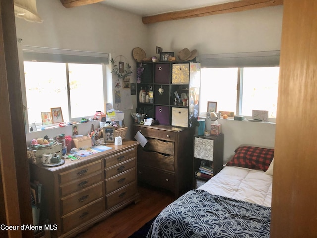 bedroom featuring beamed ceiling, dark hardwood / wood-style flooring, and multiple windows