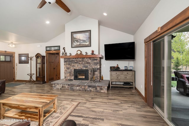 living room featuring ceiling fan, a fireplace, hardwood / wood-style flooring, and high vaulted ceiling