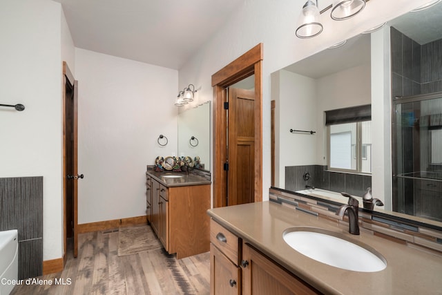 bathroom with vanity, backsplash, plus walk in shower, and hardwood / wood-style flooring