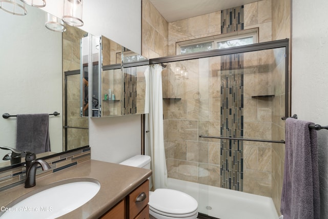 bathroom featuring toilet, vanity, and tiled shower