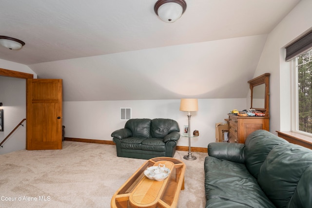 carpeted living room featuring plenty of natural light and lofted ceiling