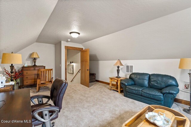 carpeted home office with vaulted ceiling and a textured ceiling