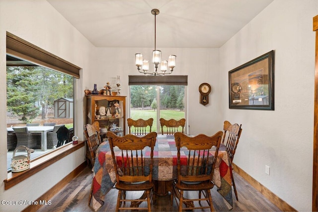 dining area featuring dark wood-type flooring and a chandelier