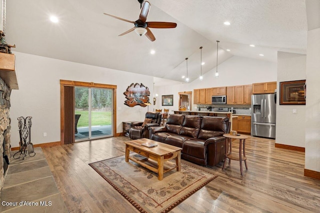 living room with high vaulted ceiling, a textured ceiling, light hardwood / wood-style flooring, and ceiling fan